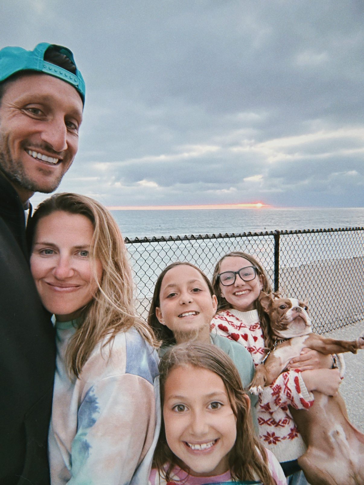 Randall and Kristi Creasey with their three daughters and their Boston terrier at the beach at sunset